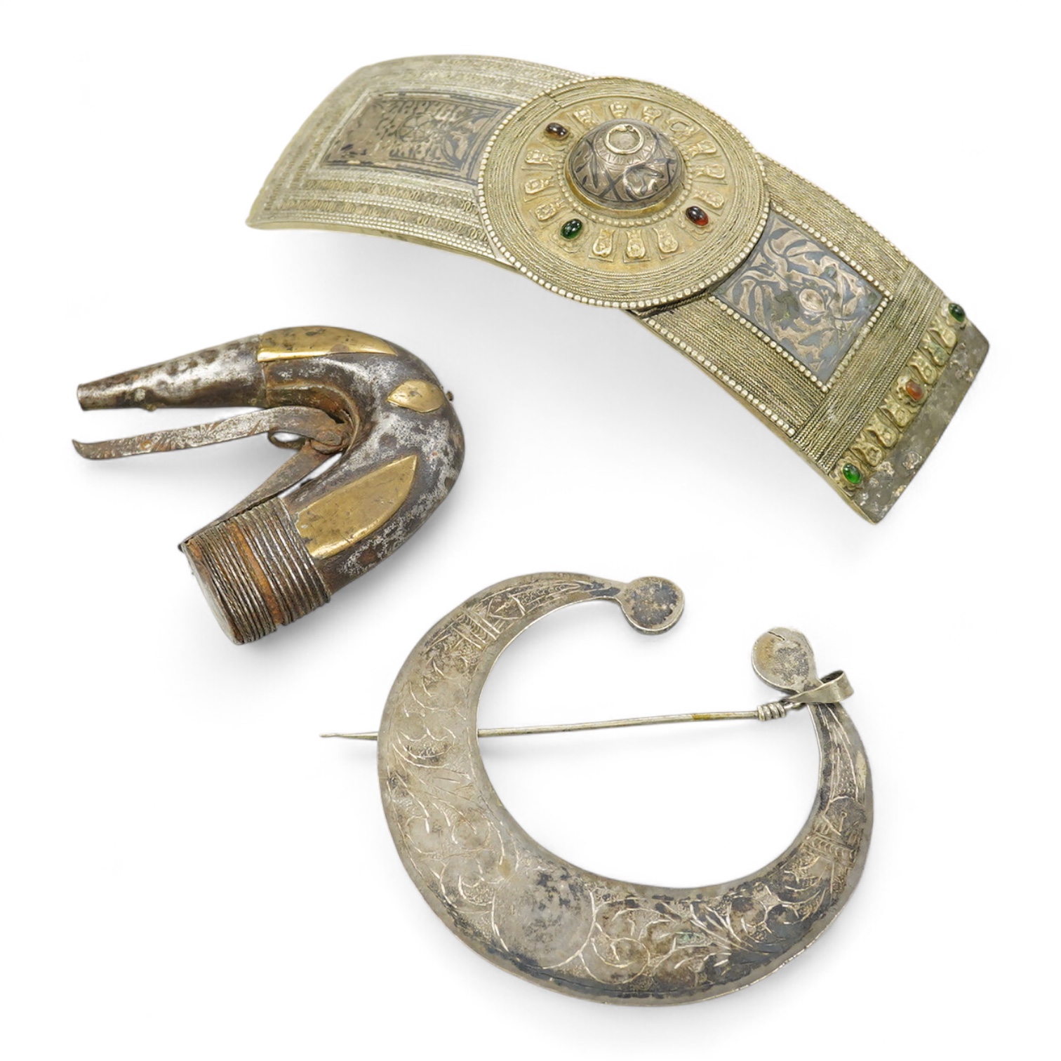 A niello work belt buckle, 21cm wide, an Arab white metal cloak brooch and a powder flask
